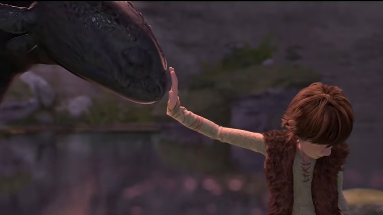 Hiccup touching Toothless' face