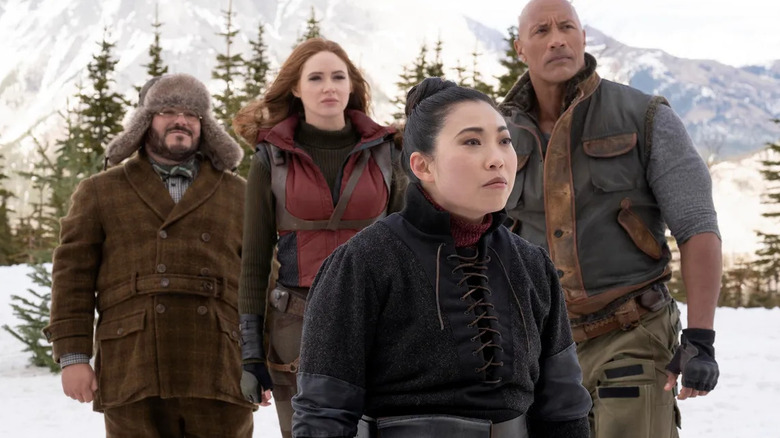 Jack Black as Professor Oberon, Karen Gillan as Ruby Roundhouse, Awkwafina as Ming, and Dwanye Johnson as Dr. Bravestone standing in a snowy forest in "Jumanji: The Next Level."