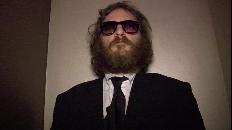 Joaquin Phoenix in a suit and sunglasses