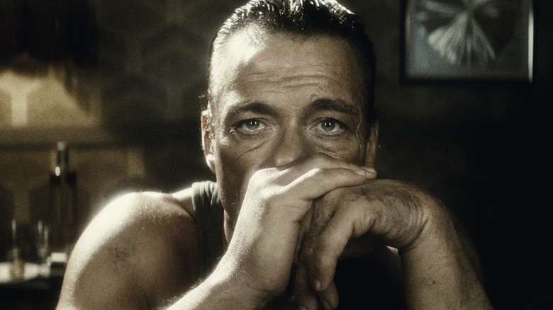 Van Damme folds his hands.