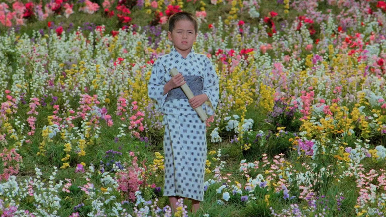 Mitsunori Isaki stands in a field of flowers