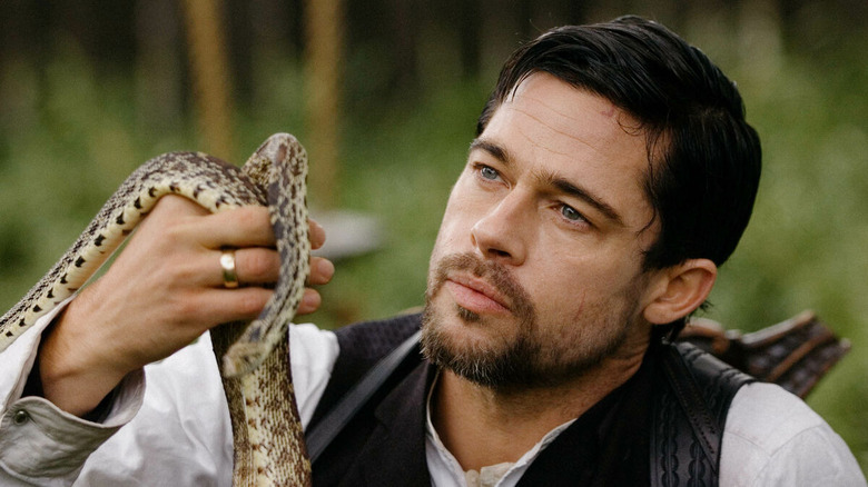 Brad Pitt holds up a snake