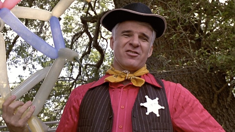 Steve Martin holds a balloon animal