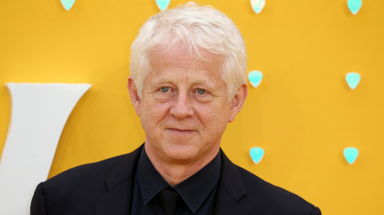Richard Curtis in front of yellow wall
