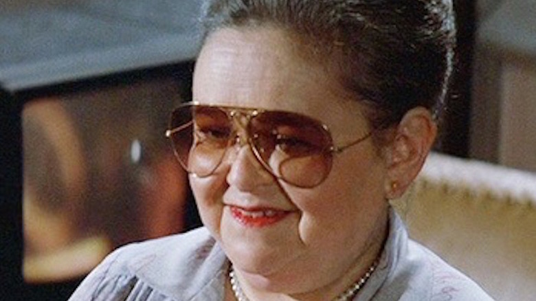 Zelda Rubinstein, wearing tinted glasses, smiles