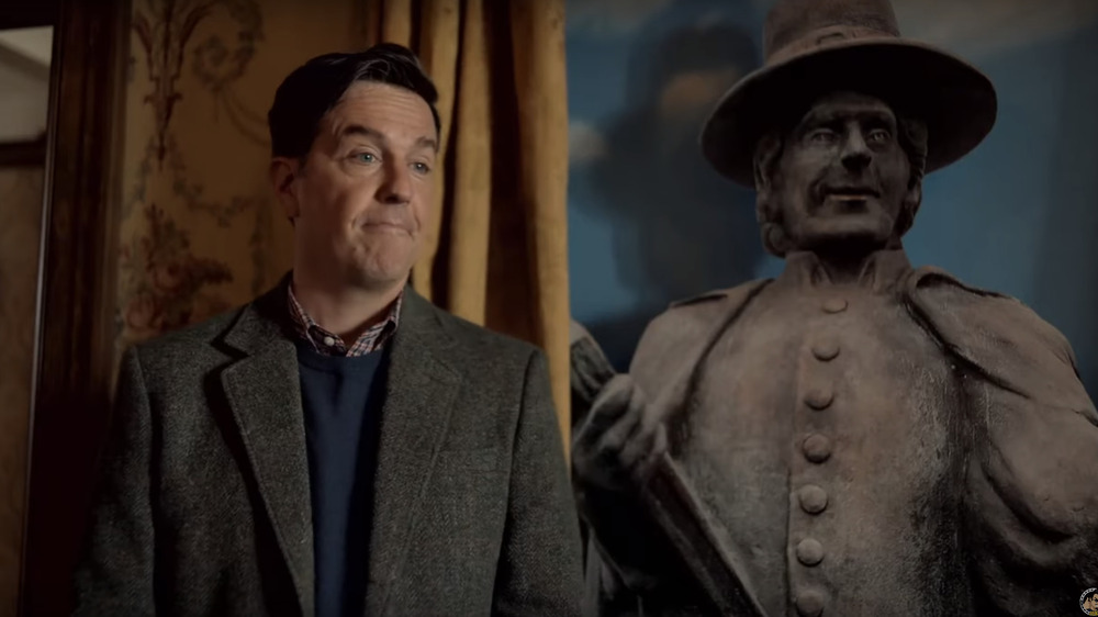 Ed Helms beside statue