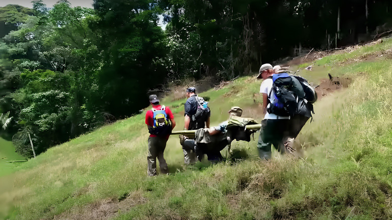 Men carrying Steve Rankin on makeshift stretcher