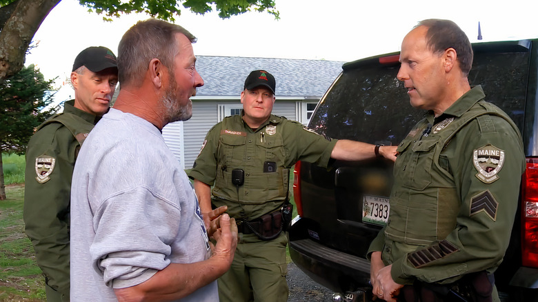 Three Fish and Game Wardens interviewing a person of interest