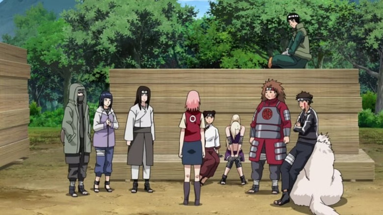 The Konoha 11 standing around Ino while she sits and cries