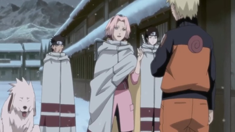 Sakura speaking to Naruto while Kiba, Sai, and Akamaru stand by