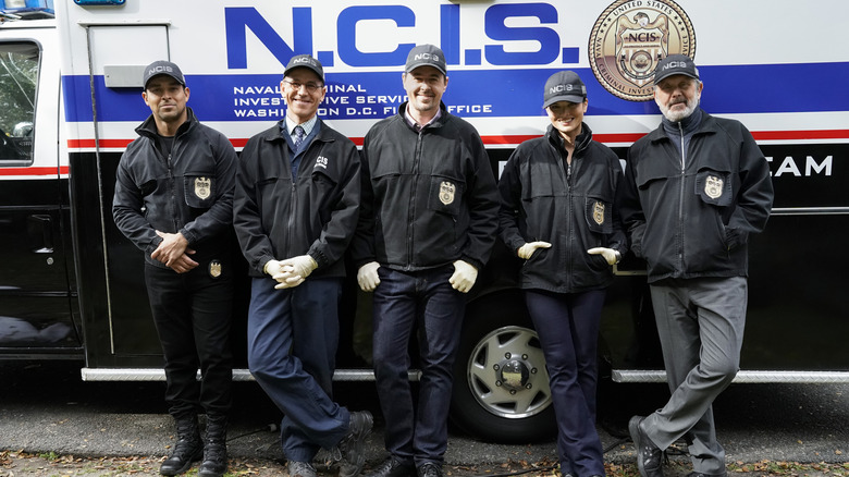 NCIS Season 20 cast posing outside NCIS truck