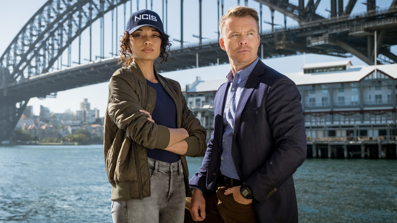 Mackey and Dempsey in front of a bridge