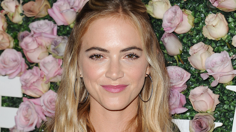 Emily Wickersham smiling flower wall