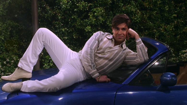 Fez posing on a car