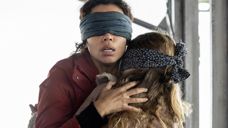 A blindfolded woman holding a child