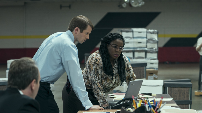 Edie and John lean over a laptop