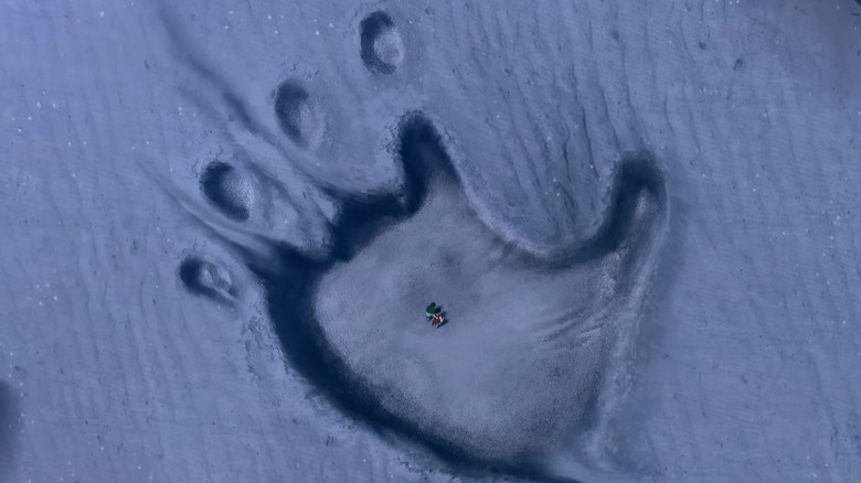 Charlie and Mike standing in Kong's footprint