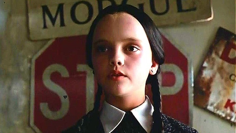 Wednesday Addams in front of signs