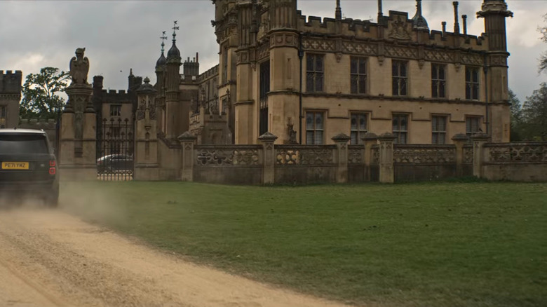 Cars approach gigantic English mansion 