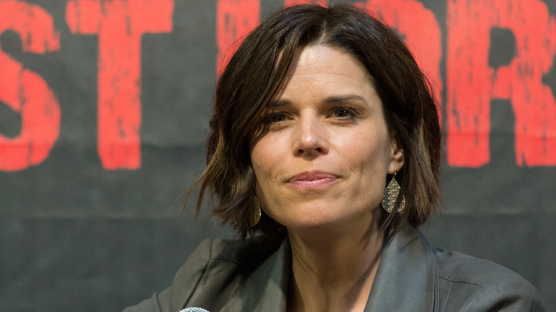 Neve Campbell sits on panel 