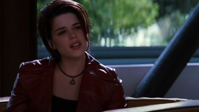 Neve Campbell sits in sunny waiting room