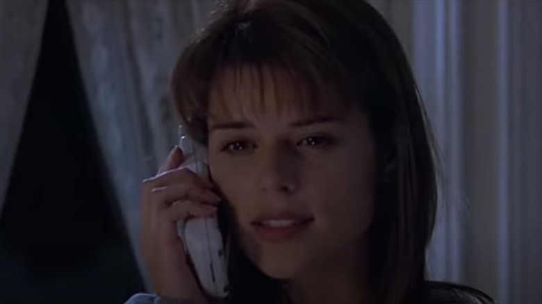 Neve Campbell on phone in her bedroom