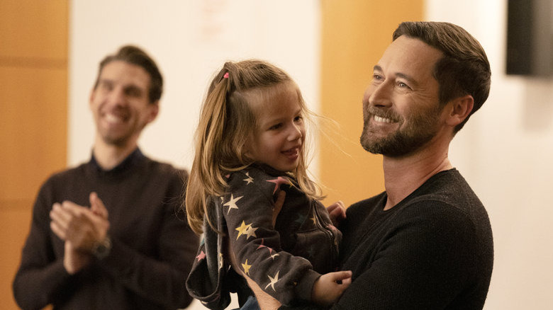 Max holding Luna as they both are smiling on New Amsterdam