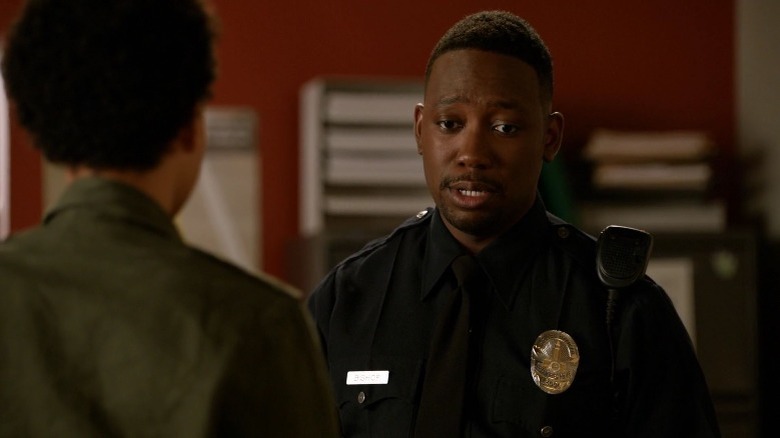 Winston in police uniform talking to KC