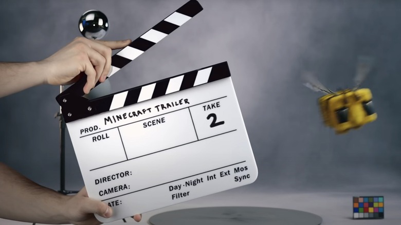 A hand holds a clapper board with 