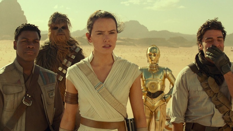 Finn, Chewbacca, Rey, C3P0, and Poe standing on Tatooine