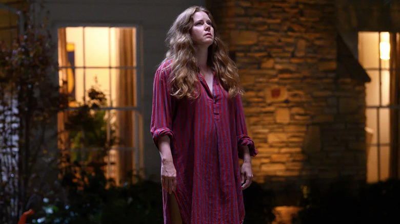 Mother stands outside her house at night