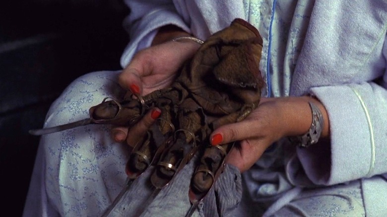 Freddy Krueger's glove in a woman's lap