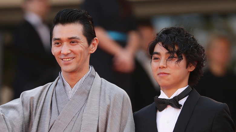 Nijiro Murakami standing beside his father 