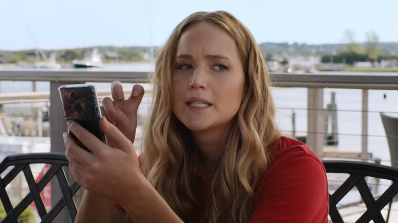 Maddie giving air quotes while holding phone