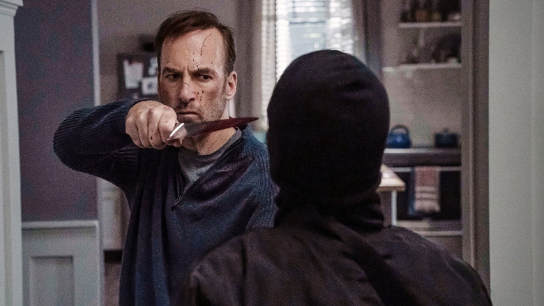 Bob Odenkirk as Hutch Mansell holding a knife in Nobody