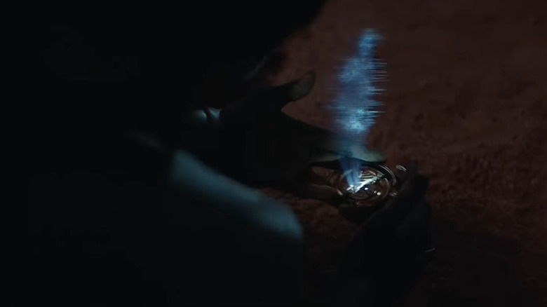 Reva holds a transmitter with a blurry image of Bail Organa