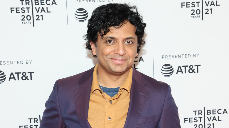 M. Night Shyamalan purple jacket yellow shirt