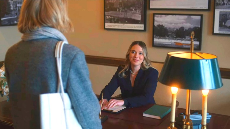 A receptionist speaks to Nora Brannock