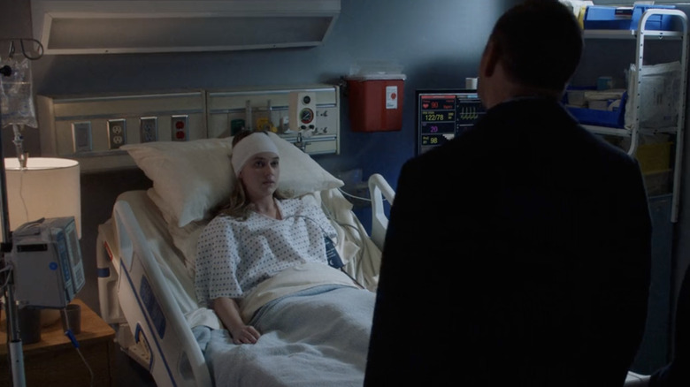 Grace Spence lies on a hospital bed in front of Danny