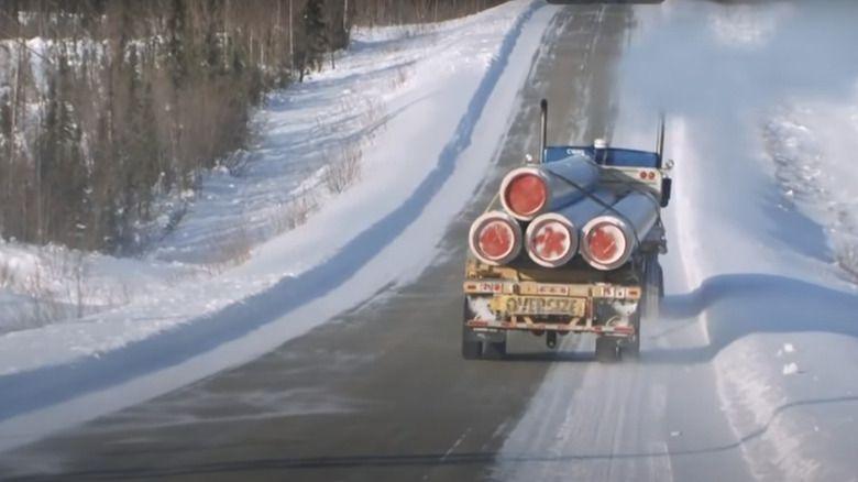 A truck driving down the highway with cargo