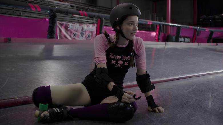 Mel sitting on ground in roller derby uniform