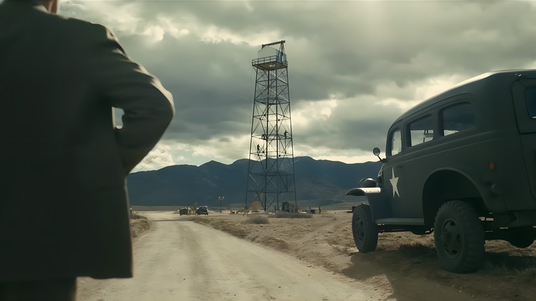 A man, tower, and car on the Trinity Test site