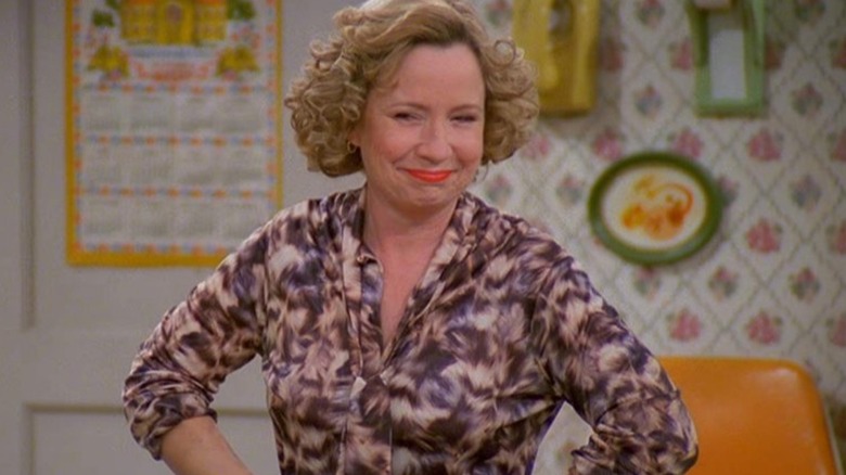 Kitty Forman smiling with her hands on her hips