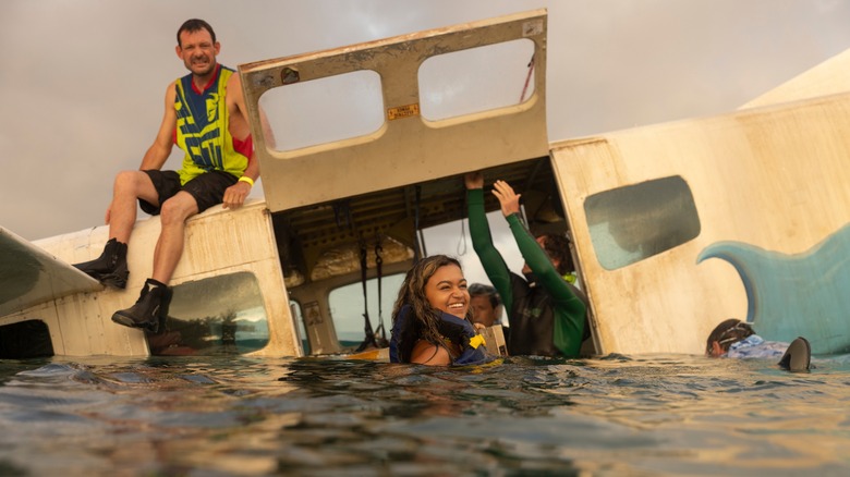 Madison Bailey smiling during plane crash shoot for Outer Banks