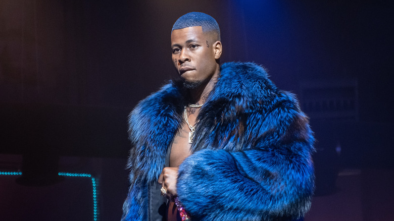 Lil' Murda on stage in a blue fur coat