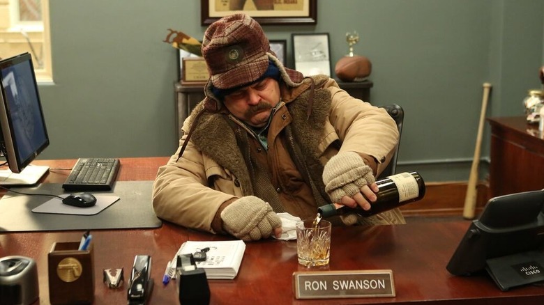 Ron in coat and hat pouring whiskey