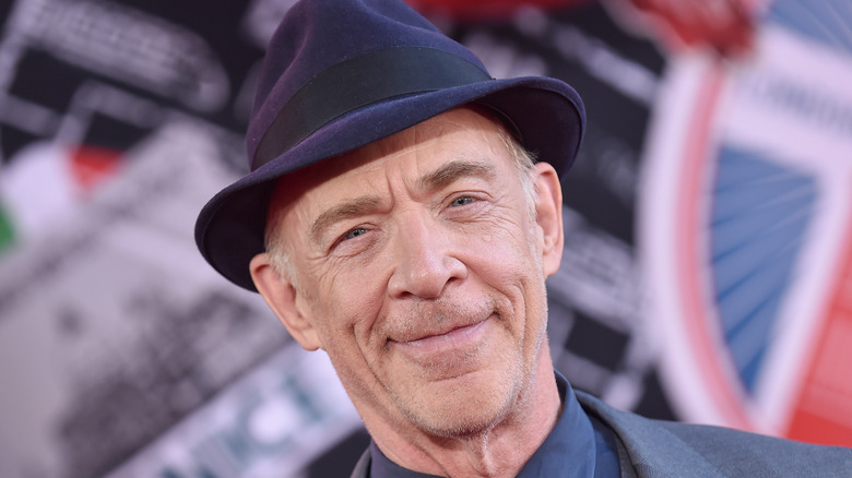 JK Simmons smiles in a fedora 