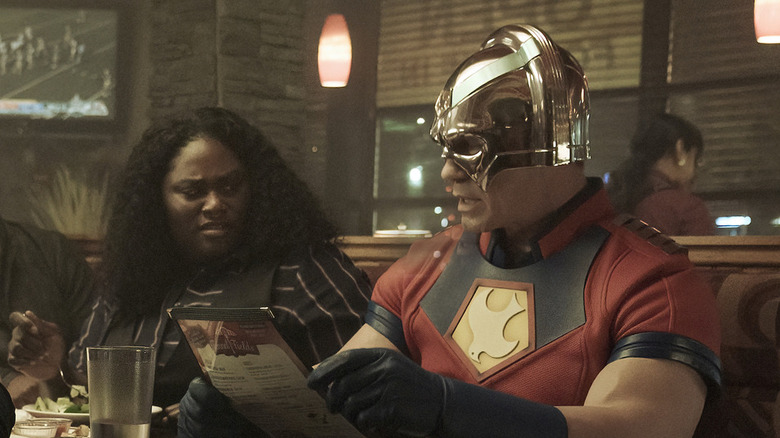 Danielle Brooks and John Cena sitting in a booth in "Peacemaker"