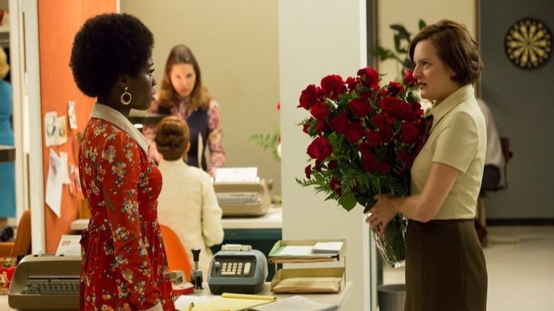 Peggy holds flowers and talks to Shirley