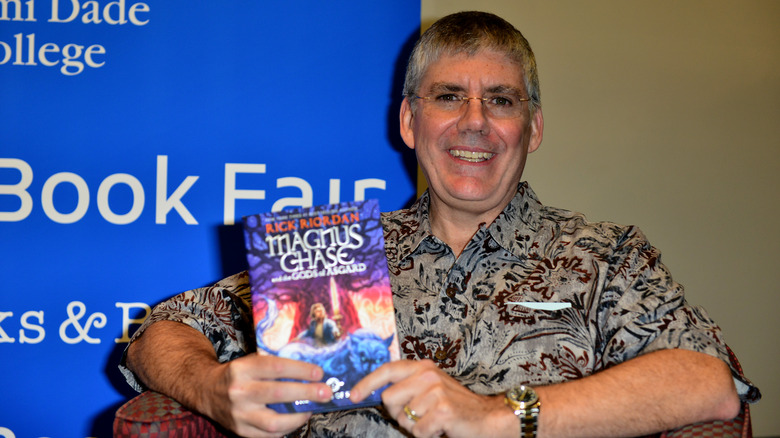 Rick Riordan holding book at event